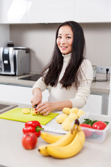 Photo of young brunette cutting vegetables in kitchen