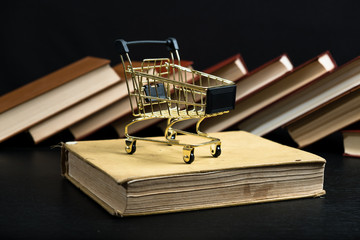 Stack of old books on a wooden shelf and shopping carts