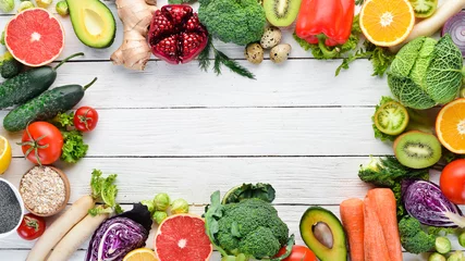 Tuinposter Verse groenten en fruit op een witte houten achtergrond. Gezonde biologische voeding. Bovenaanzicht. Gratis exemplaar ruimte. © Yaruniv-Studio
