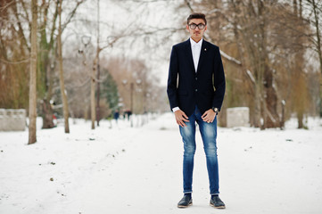 Stylish indian student man in suit and glasses posed at winter day outdoor.