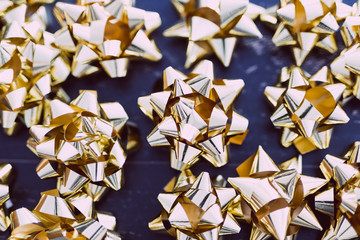 golden gift wrapping ribbon decorations on dark wooden surface