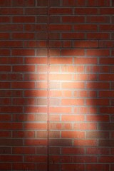 Fototapeta na wymiar Sunlight casts an unusual pattern on modern brickwork in a CIty centre