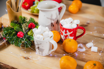 Citrus, marshmallows and Christmas attributes on the surface of a wooden table