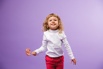 Cheerful little girl holding Christmas lollipop