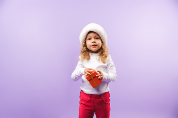 Obraz na płótnie Canvas Cheerful little girl holding Christmas present box