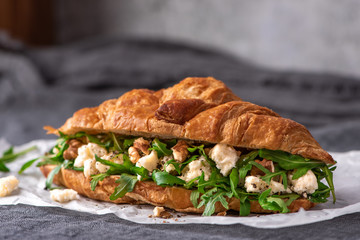 Delicious sandwich. Croissant with arugula, goat cheese and walnuts.