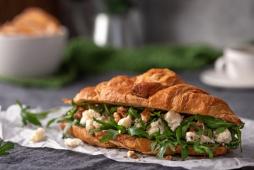 Delicious sandwich. Croissant with arugula, goat cheese and walnuts.