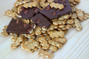 chocolate with nuts and biscuits with poppy on wooden background