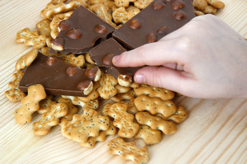 chocolate with nuts and biscuits with poppy on wooden background