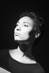 portrait of beautiful sensual woman looking down on dark background 