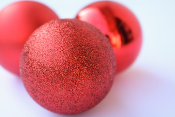 Primo piano tre bocce di natale rosse su sfondo bianco