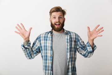 Naklejka premium Happy bearded man dressed in plaid shirt standing
