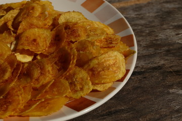 close up of thin crispy banana on wooden table background the concept of processing food banana products