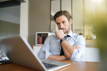Naklejka premium Relaxed attractive businessman working in modern office