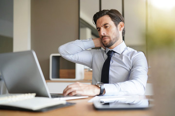 Fototapeta premium Stressed handsome business man looking at laptop in office