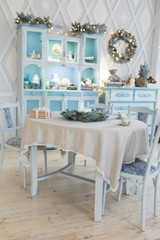 Light blue Christmas Happy new year interior with pottery white table fir tree decorations candles tea cups
