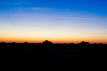 Sunset on the red Kalahari desert with a blue and orange sky in southern Namibia, Africa