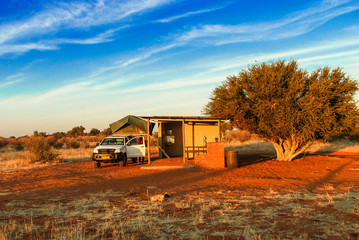 Pickup 4x4 car with a tent on the roof on road trip has a stop at a camping rest area in desolate...