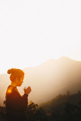 Asian Woman Standing drinking coffee and relaxing in sunrise and sunshine light enjoying life her...