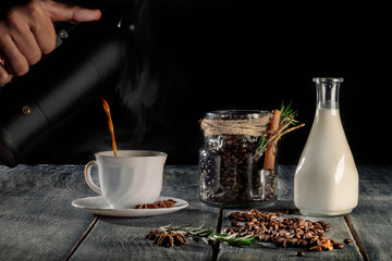 Hot Coffee cup and coffee beans with bottle of milk on the wooden table