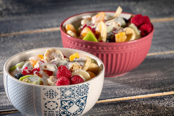 Porridge with berries and nuts in a bowl for healthy breakfast on rustic wooden background