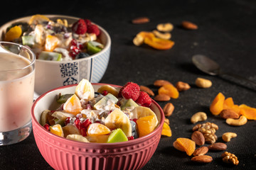 Porridge with berries and nuts in a bowl with yogurt for healthy breakfast on rustic wooden background. top view