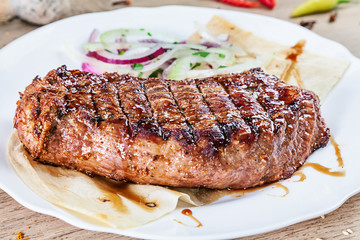 close up grilled beef fillet steak with herbs and spices on white plate. Meat, vegetables. Food for recipe. Tasty bbq cuisine.