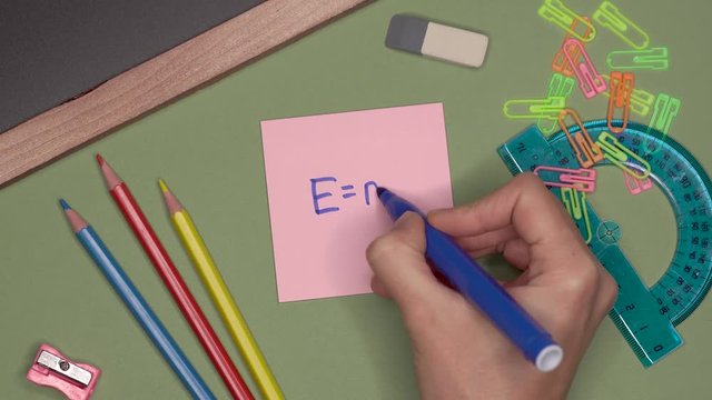 School concept. Womans hand writing E=mc2, einsteinian theory of relativity