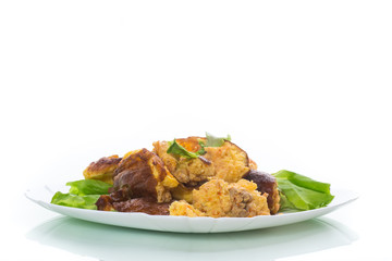 fried omelet with meat and greens in a plate