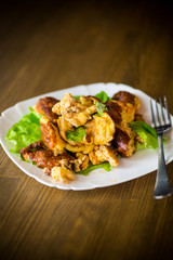 fried omelet with meat and greens in a plate