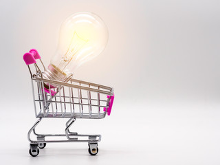 Light bulb in the shopping cart on white background. Saving energy and business concept.