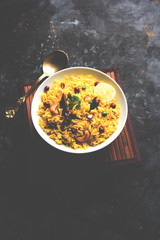 Lemon Rice is a South Indian turmeric rice or maharashtrian recipe called fodnicha bhat using leftover rice garnished with nuts curry leaves and lemon juice, selective focus