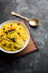 Lemon Rice is a South Indian turmeric rice or maharashtrian recipe called fodnicha bhat using leftover rice garnished with nuts curry leaves and lemon juice, selective focus