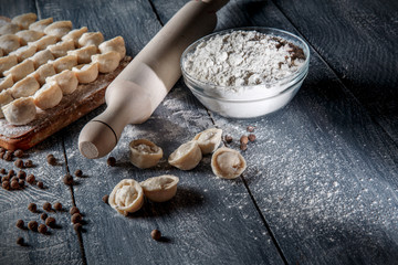 Pelmeni, ravioli, dumplings with meat on dark wood background. Fresh dough.