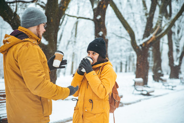 Fototapeta na wymiar couple walking by snowed city park talking socializing. romantic date in winter time