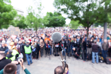Microphone in focus against blurred protest or public demonstration