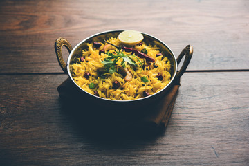 Lemon Rice is a South Indian turmeric rice or maharashtrian recipe called fodnicha bhat using leftover rice garnished with nuts curry leaves and lemon juice, selective focus