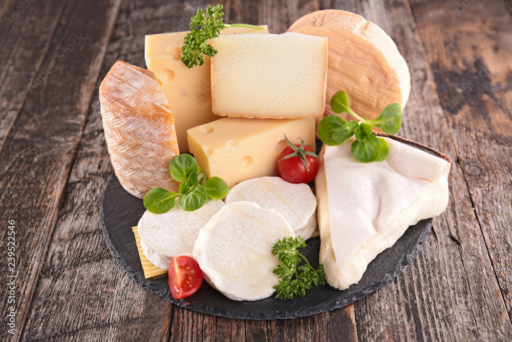 Wall mural assorted cheese on wood background