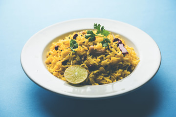 Lemon Rice is a South Indian turmeric rice or maharashtrian recipe called fodnicha bhat using leftover rice garnished with nuts curry leaves and lemon juice, selective focus