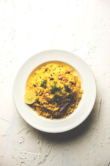 Lemon Rice is a South Indian turmeric rice or maharashtrian recipe called fodnicha bhat using leftover rice garnished with nuts curry leaves and lemon juice, selective focus