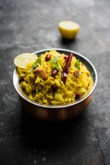 Lemon Rice is a South Indian turmeric rice or maharashtrian recipe called fodnicha bhat using leftover rice garnished with nuts curry leaves and lemon juice, selective focus