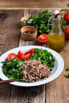 Healthy cooked buckwheat grain salad with fresh vegetables