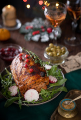 Grilled pork loin on the Christmas table with Christmas lights in the background