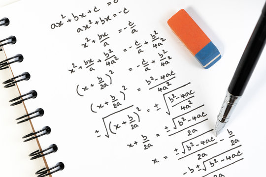 Handwriting of mathematics quadratic equation formula on examination, practice, quiz or test in maths class. Solving exponential equations background concept.