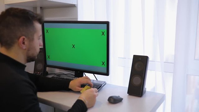 Man using PC computer with green screen chroma key at home rewrite a number of credit card
