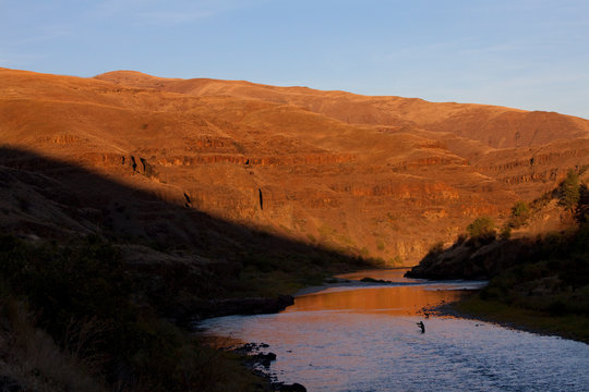 A fly fisherman casting for steelhead trout on the Grand Ronde River in south eastern Washington State USA