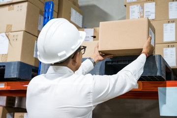 Businessman holding products boxes in the warehouse checking for shipping to customer