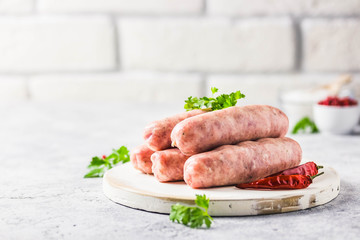 Raw sausages with spices, herbs. Selective focus, space for text.