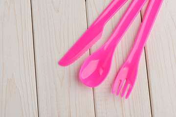 Pink cutlery set on wooden