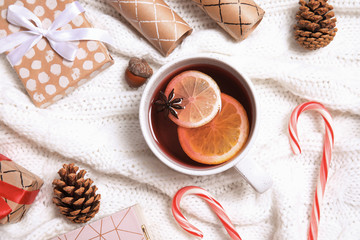 Flat lay composition with cup of hot winter drink on warm knitted plaid. Cozy season